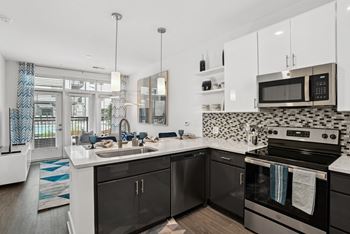 A kitchen with black and white appliances and a sink